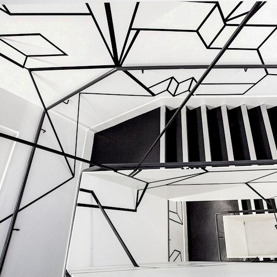 A photograph of a black and white stairs with geometric patterns running down them.