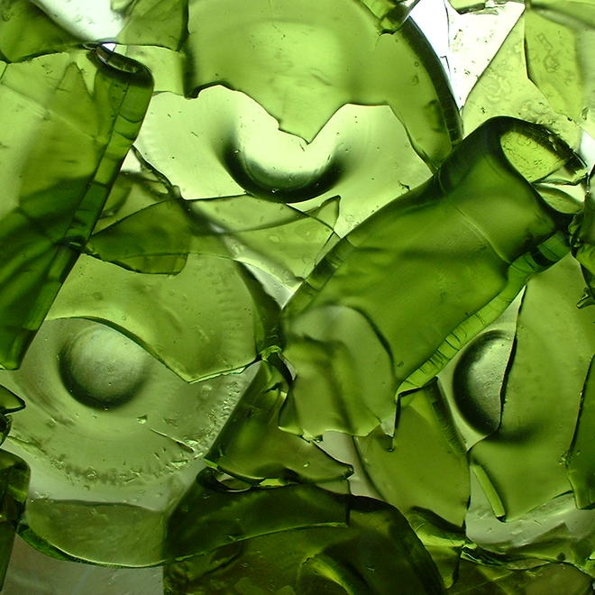 A photograph of broken green glass bottles